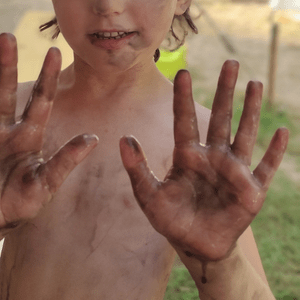 schmutziges Kind hält die Hände hoch